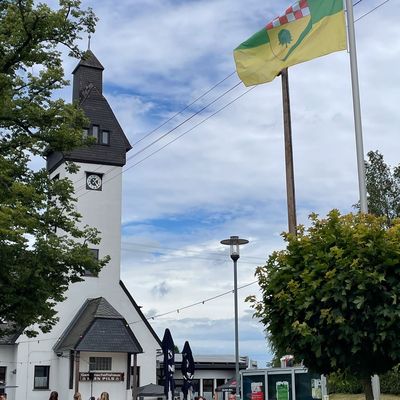 Kirche in Oberbrombach mit Fahne und Besuchern